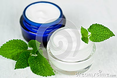 Face cream in jars with urtica Stock Photo