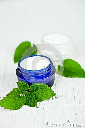 Face cream in jars with urtica leaves Stock Photo