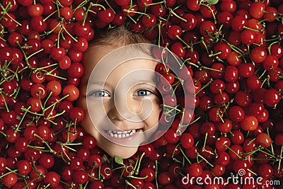 Face of a happy surrounded by a large pile of fruits of red, ripe, juicy cherries. Stock Photo