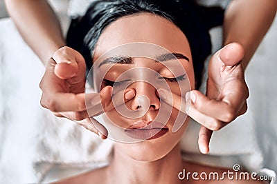 Face massage. Fingers of masseur. Nose and hands closeup. Facial skin care. Woman at beauty spa salon Stock Photo