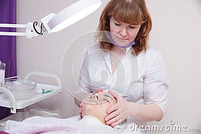 Applying the cream to the skin of the girl at the beautician after the procedure of mesotherapy Stock Photo