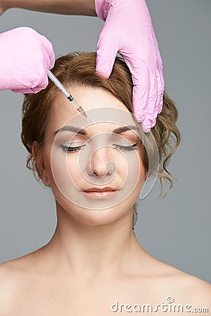 Face needle injection. Young woman cosmetology procedure. Doctor gloves Stock Photo