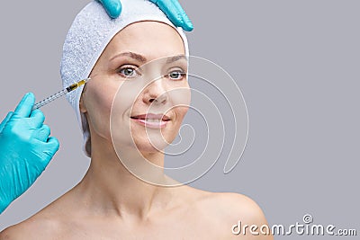 Face needle injection. Young woman cosmetology procedure. Doctor hand Stock Photo