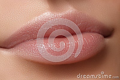 Face part. Beautiful female lips with natural makeup, clean skin. Macro shot of female lip, clean skin. Fresh kiss. Stock Photo