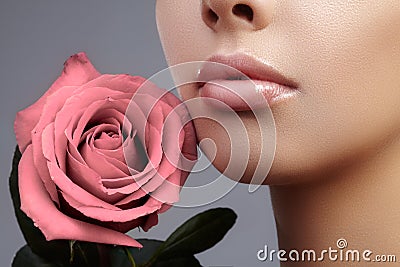 Face part. Beautiful female lips with natural makeup, clean skin. Macro shot of female lip, clean skin. Fresh kiss. Stock Photo