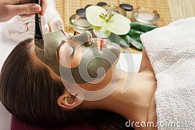 Face peeling mask, spa beauty treatment, skincare. Woman getting facial care by beautician at spa salon, close-up.Spa clay mask o Stock Photo