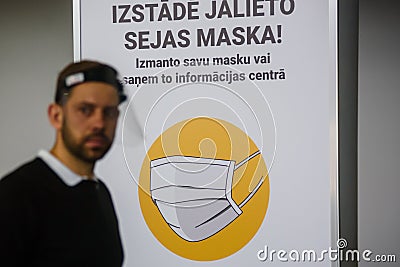 Face protective mask symbol on banner at exhibition centre Editorial Stock Photo