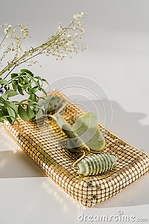 Face quartz roller for anti-aging facial massage, chinese guasha beauty tool, golden bag Stock Photo