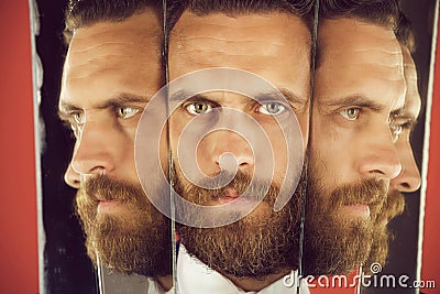 Face of serious bearded hipster man, businessman reflecting in mirror Stock Photo