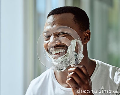 Face, shaving and razor with a black man grooming in the bathroom mirror of his home for beauty or skincare. Beard Stock Photo