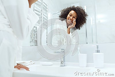 Face skin care. Girl removing makeup with cotton pad at bathroom Stock Photo