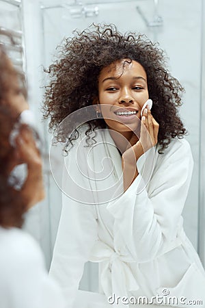 Face skin care. Girl removing makeup with cotton pad at bathroom Stock Photo