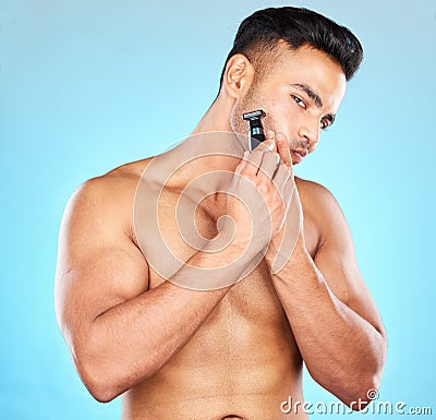 Face, skincare and man with razor shaving in studio isolated on a blue background. Hygiene, grooming and beard shave Stock Photo