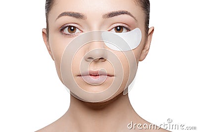 Woman applying her plaster under her eye during make up, isolated on white background. Horizontal view Stock Photo