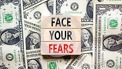 Face your fears and support symbol. Concept words Face your fears on wooden blocks on dollar bills. Beautiful background from Stock Photo