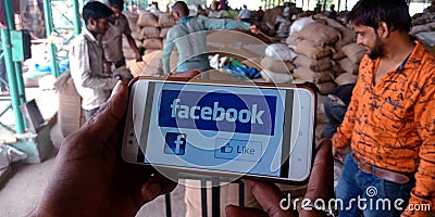 Facebook logo with like button displayed on smart phone screen at farmers market Editorial Stock Photo
