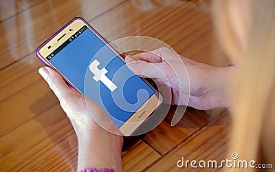 Facebook logo on the screen of cell phone. Editorial Stock Photo