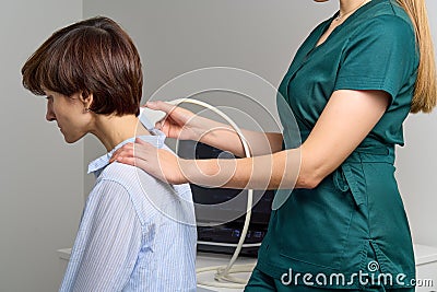 Faceless female sonographer examing neck. Healthcare worker doing ultrasound scanning Stock Photo