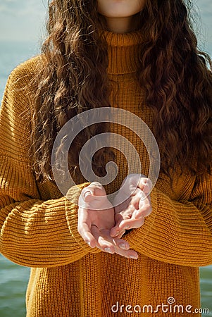 Faceless portrait of woman on a beach stretching forward out her hands Stock Photo