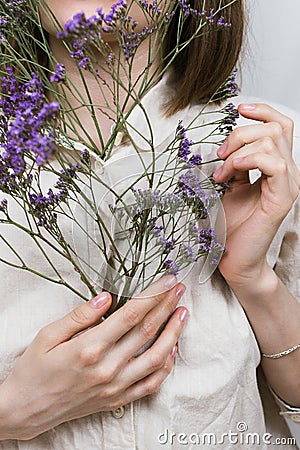 Faceless portrait of woman holding purple flowers Stock Photo