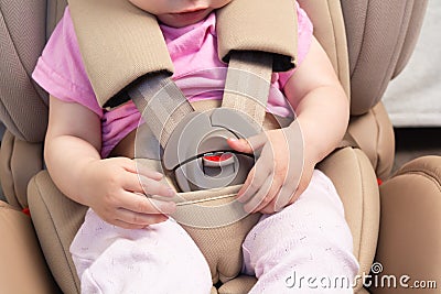 Faceless small baby sitting in special car seat with safety seatbelts Stock Photo