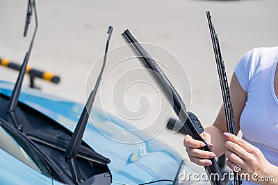 Faceless woman changing car windshield wipers. Stock Photo