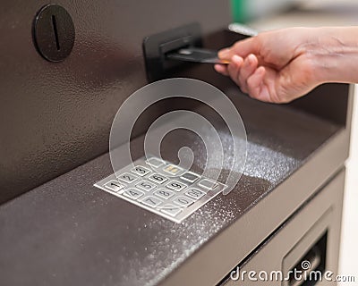 Faceless woman inserts bank card at ATM. Stock Photo