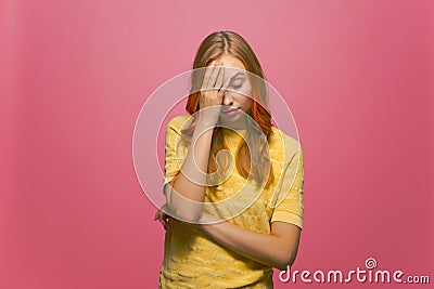 Facepalm gesture. Young woman covering face with hand, feeling shame, disappointment on pink studio background Stock Photo