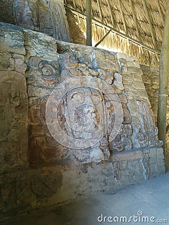 Faces carved in stone on two levels in Mayan ruins Stock Photo