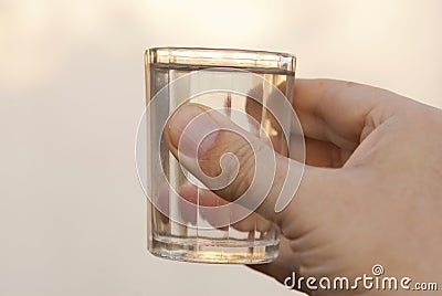 Faceted glass of vodka in his hand. Stock Photo