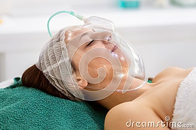 Young woman receiving cosmetic treatment with oxygen mask Stock Photo