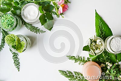 Facial body cosmetic products, leaves and flowers blossom on white desktop background whith copy space. spring skin care layout, Stock Photo