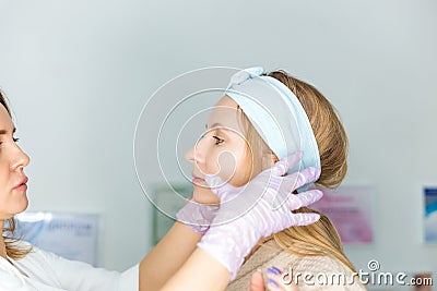 Facial skin care and protection. A young woman at a beauticians appointment. A specialist examines the face and skin Stock Photo