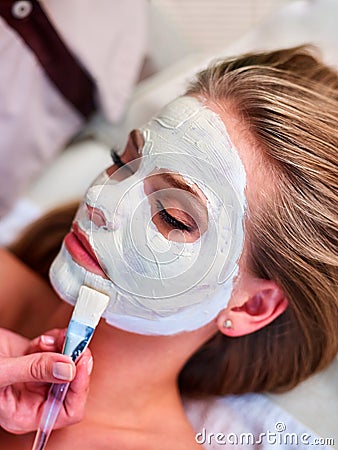 Facial treatment of woman. Clay face mask and beautician hands. Stock Photo