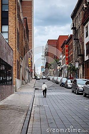 Facing back asian adult woman walking on the street on a cloudy day in Chinatown, Montreal, Quebec, Canada Editorial Stock Photo