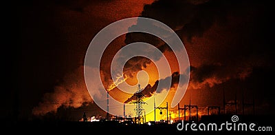 Factories at night, the silhouettes of the pipe producing a noxious smoke Stock Photo