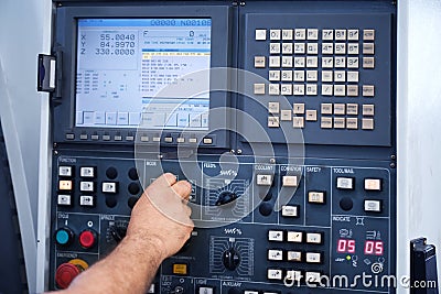 Factory engineer controlling and pressing important technology button at control panel. Stock Photo