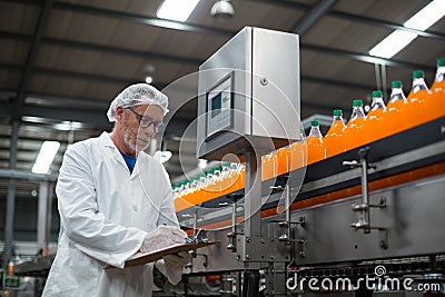 Factory engineer maintaining record on clipboard in factory Stock Photo