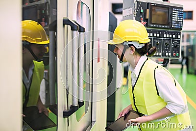 Factory female worker inspect machine Stock Photo