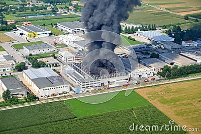 Factory fire with black smoke that causes pollution Stock Photo