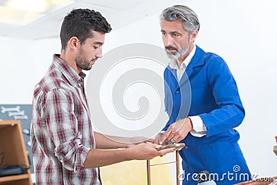 Factory manager and engineering apprentice discussing component Stock Photo