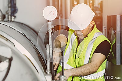 Factory service worker engineer working in factory check maintenance boiler water pump pressure pipe leak in plant Stock Photo