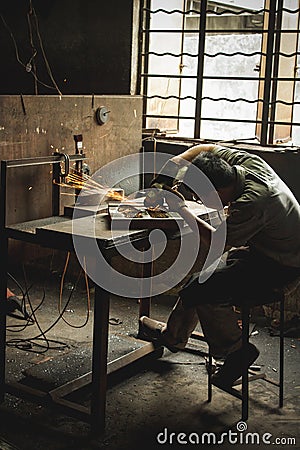 Factory worker grinding shoe mold Editorial Stock Photo