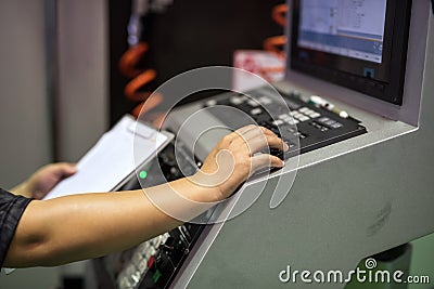 Factory worker on keyboard to command machine Stock Photo