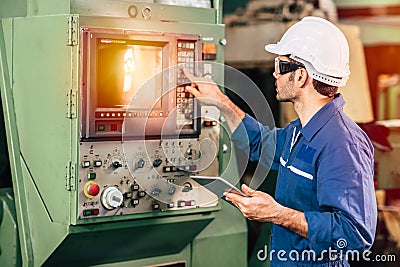 Factory worker man operate the machine, high skill labor work industry with safety clothes Stock Photo