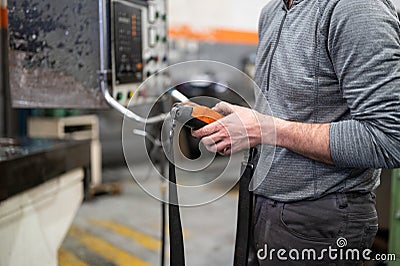 Factory worker. Technician controlling a heavy crane in factory, close up at his hands holding a crane controller. Stock Photo