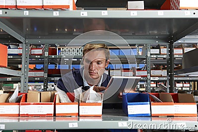 Factory Worker Using Digital Tablet In Store Room Stock Photo