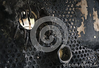 Faded and aged industrial detail - hole, metal netting with rounded pinholes, nut Stock Photo