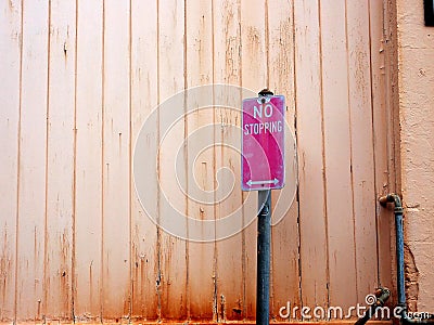 Faded No Stopping Traffic Sign and pale Wood Wall Stock Photo