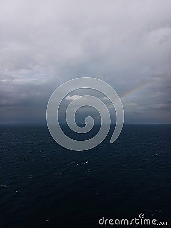 Faded rainbow in mediterranean sea Stock Photo